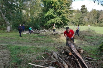 Open Newtown's Countryside Ranger, Dewi Morris, working with volunteers to create habitat piles for wildlife copyright MWT