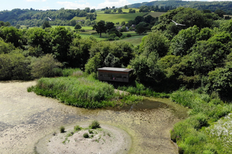 Aerial shot of Llyn Coed y Dinas Nature Reserve and its bird hide