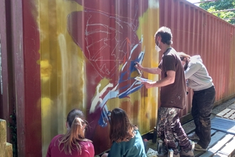 Close of young people spray painting 
